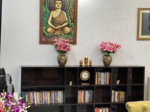 兰奇Krishna Kunj的两瓶花的架子和一幅佛陀的画