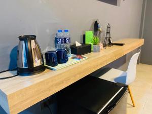 武里南S1 City Hotel Buriram的木制柜台配有水壶和瓶装水