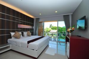 皮皮岛Phi Phi Rimlay Resort的一间带大床的卧室和一个阳台