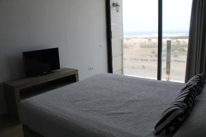 科蒂略Apartamentos Tocororo的一间卧室配有一张床和一台平面电视