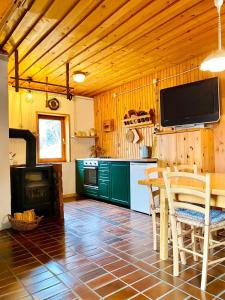 OrtnekFamily Peace Chalet Brinovska & Scenic Mt Views的厨房配有桌子,墙上配有电视。
