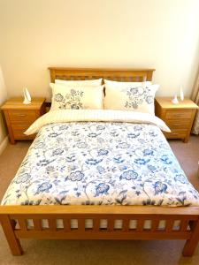 彼得伯勒Luxurious two-bedroom apartment in the centre of Peterborough的一间卧室配有一张带蓝色和白色棉被的床