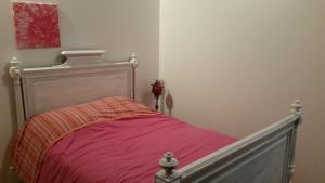圣佩赖Gîte Les Cadichons de la Grange的一间卧室配有一张带粉色毯子的床