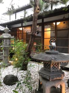 奈良仔鹿 kojika的一座日式花园,在一座建筑前设有一座石雕