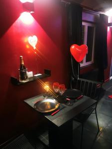 LignéLoft d'amour的红色的房间,配有带心灯和酒杯的桌子