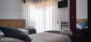 奥耶多Posada Ojedo Los Ñeros的酒店客房设有两张床和窗户。