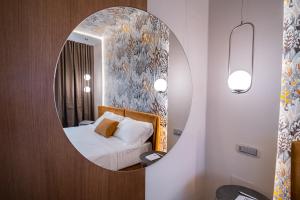卡斯特罗齐耶罗利欧拉酒店的镜子反射着卧室,卧室里配有一张床