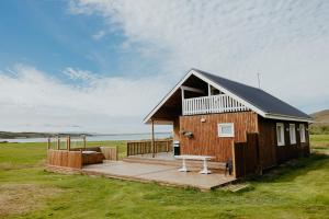 BarðBrúnastaðir Holiday Home的小屋设有甲板和长凳