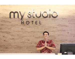 SedatiMy Studio Hotel Juanda Airport Surabaya的站在酒店标志前的人