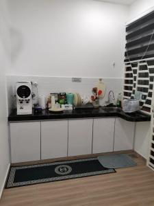克提Homestay Qaseh Kerteh的厨房配有白色橱柜和黑色台面