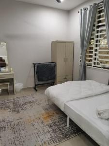 克提Homestay Qaseh Kerteh的一间卧室配有一张床、一张书桌和一个窗户。