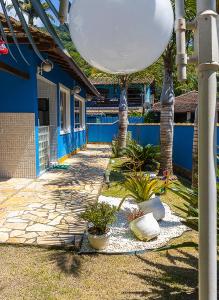 阿布拉奥Casa azul Ilha Grande的一座蓝色的建筑,在院子里种有树木和植物