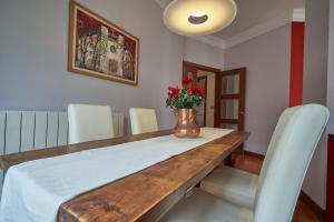 毕尔巴鄂Apartamento BIO Exclusivo con mirador en Bilbao y aparcamiento público gratuito的餐桌、白色椅子和花瓶