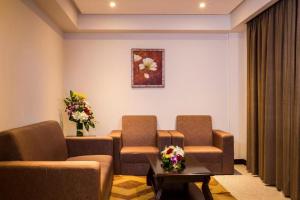 麦纳麦门罗套房及酒店的一间配有沙发、椅子和鲜花的等候室