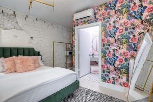 加尔维斯敦The Oleander Hotel Room Number 3的一间卧室设有一张床和花卉墙