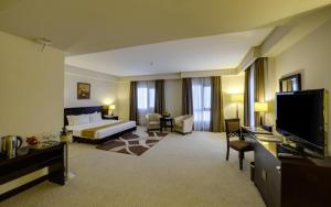 麦纳麦门罗套房及酒店的配有一张床和一台平面电视的酒店客房