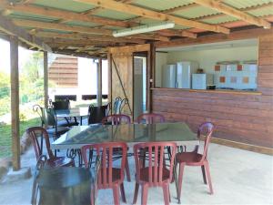 AtihaFare Arana Mooréa Guesthouse的一个带桌椅的庭院和一间厨房