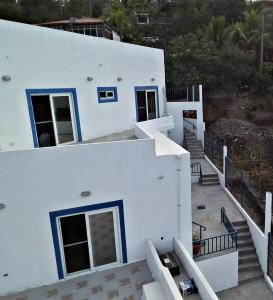 埃尔蒙特La Leona 1的白色的房子,设有蓝色的门和楼梯