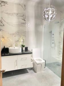 苏莎亚5 Star Villa minutes from Airport and Beaches的白色的浴室设有水槽和卫生间。