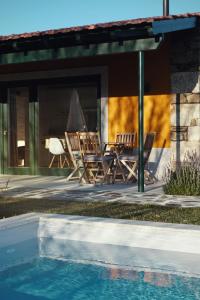 塔布阿苏Quinta do Monte Travesso - Country Houses & Winery的一组椅子坐在游泳池旁