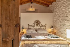 塔布阿苏Quinta do Monte Travesso - Country Houses & Winery的一间卧室设有一张带石墙的大床