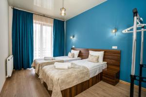 卡兹贝吉Eltisy Guest House的蓝色墙壁客房的两张床