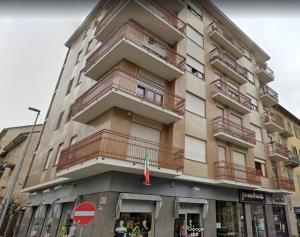 都灵La casa dei nonni - Ampio trilocale zona Lingotto的一座高大的建筑,旁边设有阳台