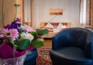 维也纳格西勒博士公寓酒店的一间带椅子和鲜花床的房间