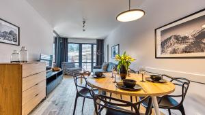 卡尔帕奇Apartament Triventi 99 z Widokiem - 5D Apartamenty的厨房以及带桌椅的用餐室。