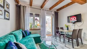 卡尔帕奇Karpaczowy Klimat przy Deptaku - 5D Apartamenty的客厅配有绿色沙发和玻璃桌
