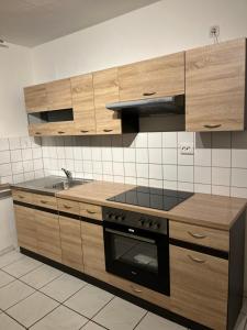 埃森Zimmer für Monteure, Handwerker oder Reisende的厨房配有木制橱柜和炉灶烤箱。