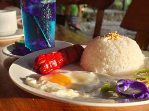 SalabusobCamp Paraiso Resort的桌上有鸡蛋和米饭的盘子