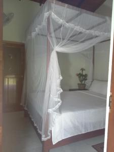 锡吉里亚Sigiriya Nature View home Stay的卧室配有白色天蓬床和盆栽植物