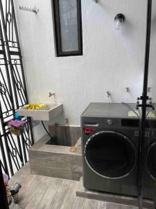 瓜达拉哈拉Alojamiento completo, con una excelente ubicación的一间带盥洗盆的浴室内的洗衣机