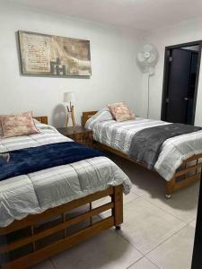 瓜达拉哈拉Alojamiento completo, con una excelente ubicación的一间卧室配有两张床和风扇