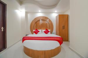 新德里Hotel Classic Paradise Inn的一间卧室配有一张大床和木制床头板