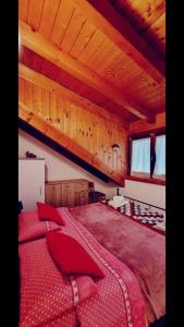 塔尔维西奥HOME PREDIL的一间卧室配有一张带红色枕头的大床