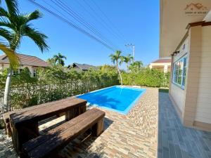 梅尔皮姆Sand-D House Pool villa B30 at Rock Garden Beach Resort Rayong的游泳池旁的木凳