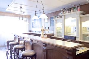 LöningenHotel Restaurant Rüwe的厨房设有带酒吧凳子的酒吧