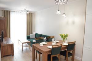 科沃布热格Apartament Luna Baltic Marina Residence的一间带桌子和沙发的用餐室