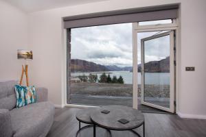 唐尼Three Lochs View, Ardelve, by Dornie的带沙发和大窗户的客厅