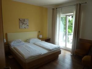 梅拉诺济马酒店的一间卧室设有一张床和一个滑动玻璃门