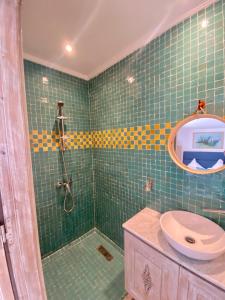 索维拉麦地那摩洛哥庭院酒店的绿色瓷砖浴室设有淋浴和水槽