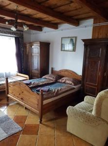 FelsőtoldBableves Vendégház的一间卧室配有一张木床和一把椅子