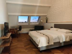 赫拉尔兹贝亨Fáilte Muur的一间卧室配有一张床、一张书桌和两个窗户。