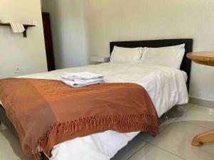 SandtonPrivate and cozy的一张铺有白色床单的床和一张棕色的毯子