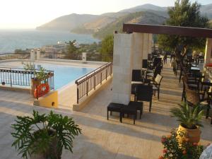 阿尔戈斯托利翁西北一室公寓酒店的一个带游泳池和桌椅的度假酒店