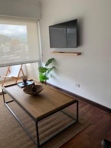 萨尔塔Sarmiento Suites Premium的客厅配有咖啡桌和平面电视。