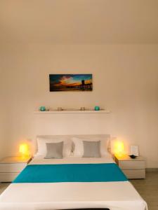 麦当那戴拉卡Villa Valentina的一间卧室配有一张带两盏灯的大型白色床。