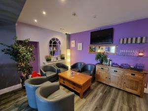 彭布罗克码头The Dolphin Hotel的一间设有紫色墙壁、椅子和桌子的等候室
